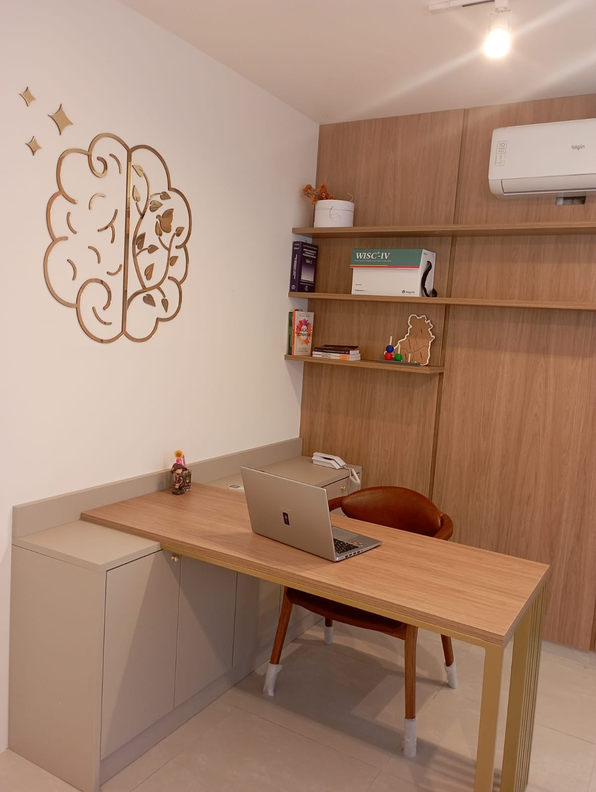 Sala de atendimento com mesa, cadeira e arte de cérebro na parede