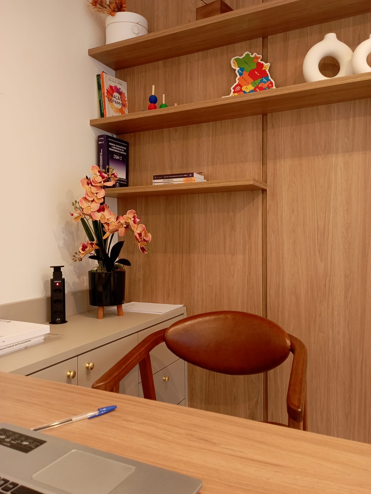 Vista da mesa de atendimento com orquídea e prateleiras